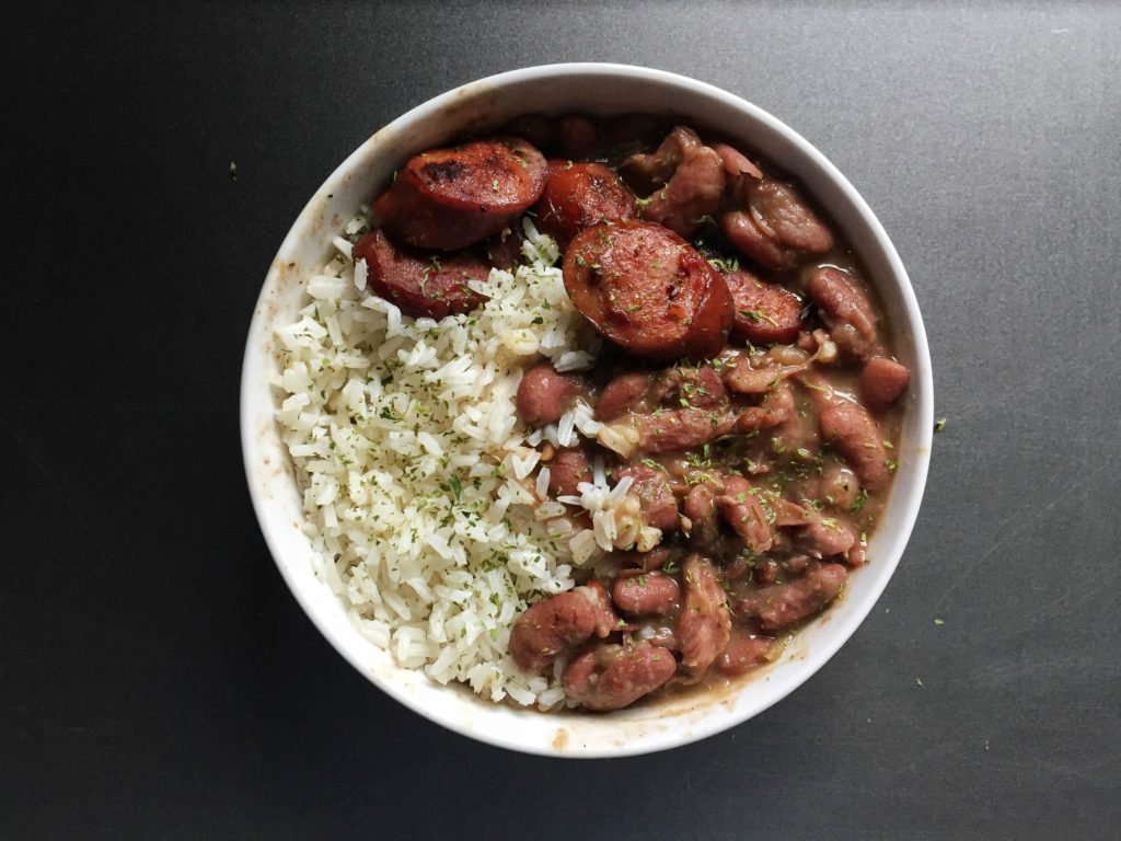 Bowl of red beans and rice with sliced smoked sausage